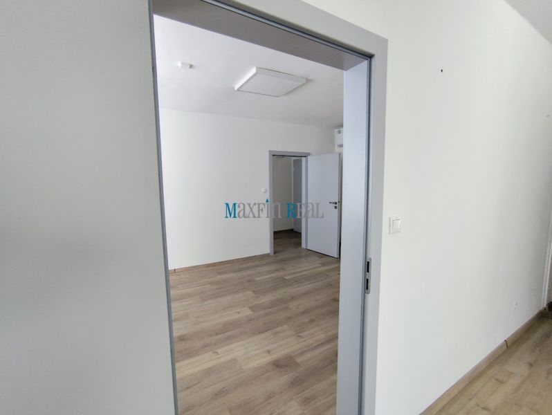 Offices with wood-patterned flooring and white walls.