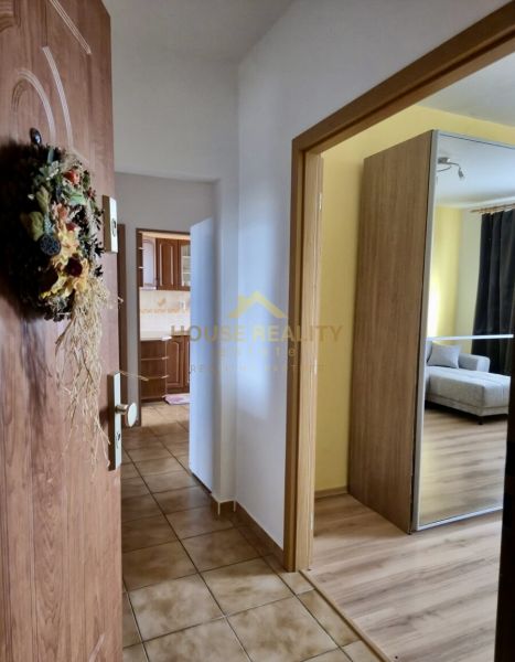 A hallway with tiles next to a floor with a wooden decor in a 3-room apartment.
