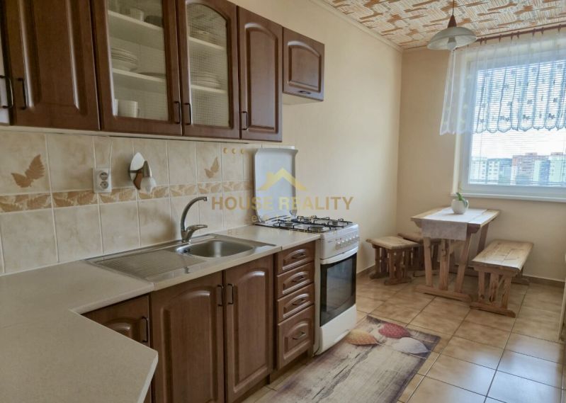 A kitchen in a 3-room apartment with a gas stove and a dining area.