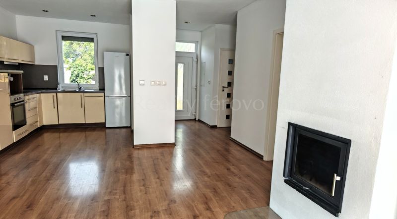 A family house kitchen with a wooden decor floor and a built-in fireplace.