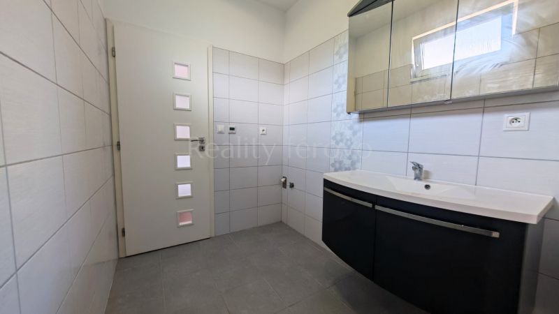 A bathroom with a sink and a mirrored cabinet in a family house.