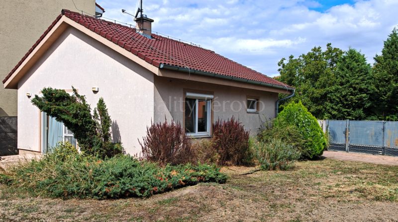 A family house in Matúškovo with a red roof and a well-maintained front garden.