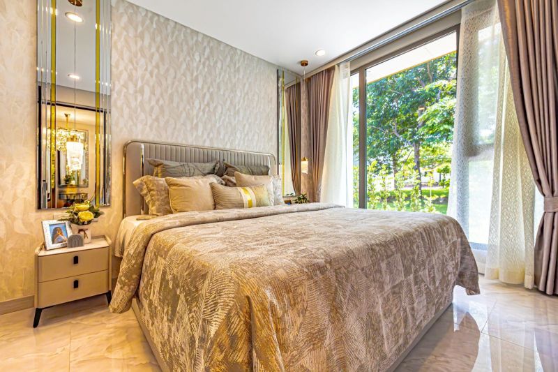 Bedroom in a holiday apartment with a comfortable bed and a large window.