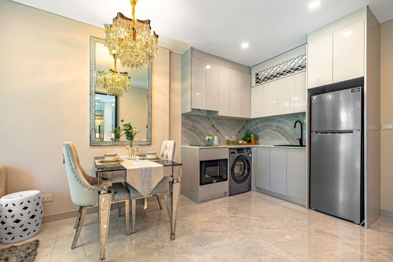A kitchen with a dining area in a holiday apartment with soft lighting and glossy surfaces.