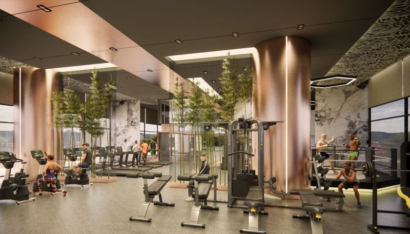 A gym in a recreational apartment with modern equipment and greenery in the interior.