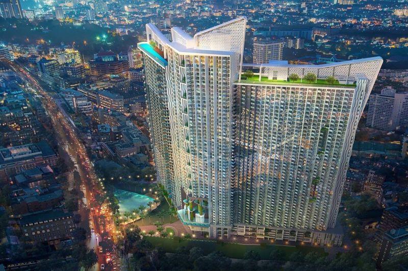 A high-rise building of a recreational apartment in Jomtien illuminated by surrounding city lights.