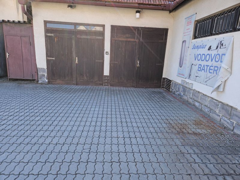 Wooden garage doors on Metodova Street in Prešov, paved yard.