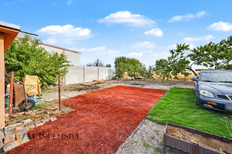 A garden at a family house in Povoda with a car and artificial turf.