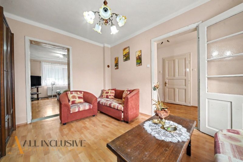 Living room with sofas and wood-patterned flooring in a family house.