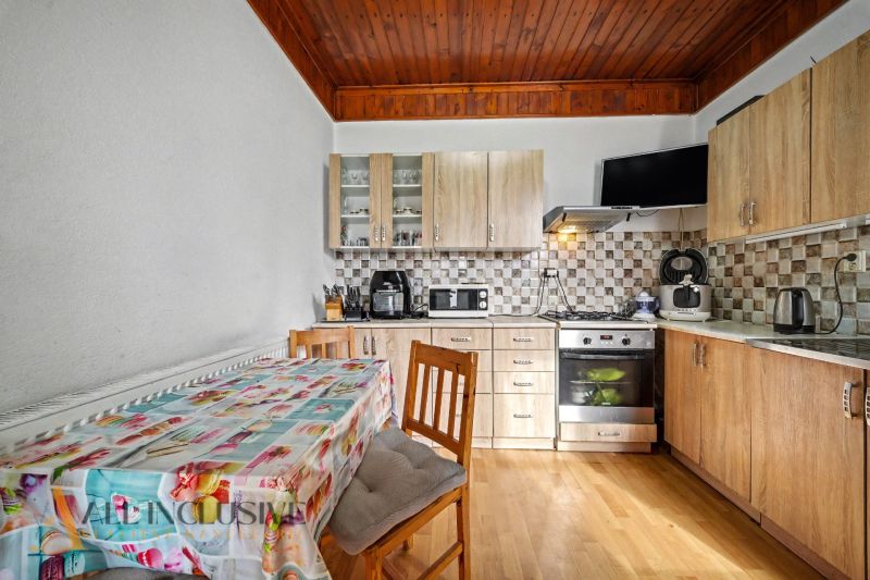 A kitchen in a family house with wooden decor on the floor and kitchen cabinets.