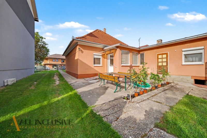 A family house in Povoda with a garden seating area, green lawn, and colorful facade.