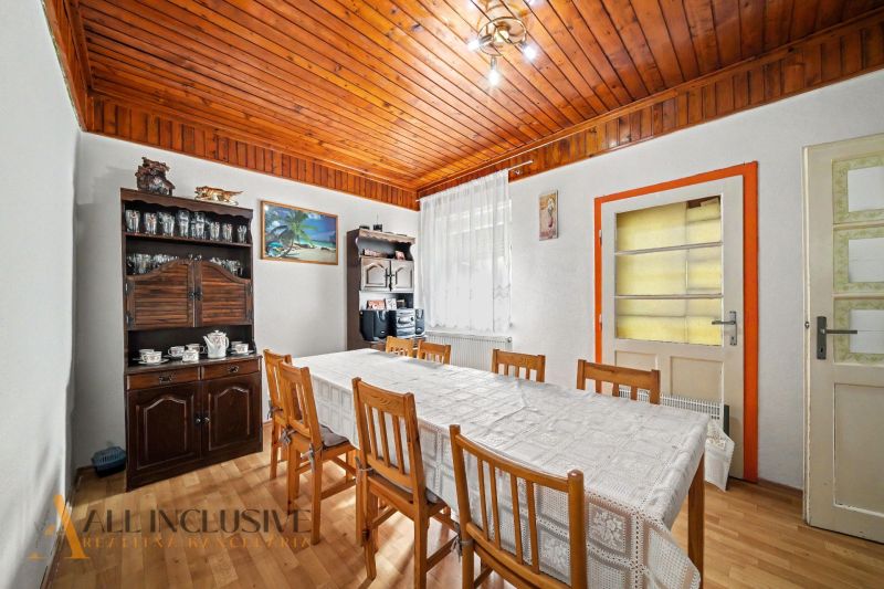A dining room in a family house with a wooden decor floor and rustic furniture.