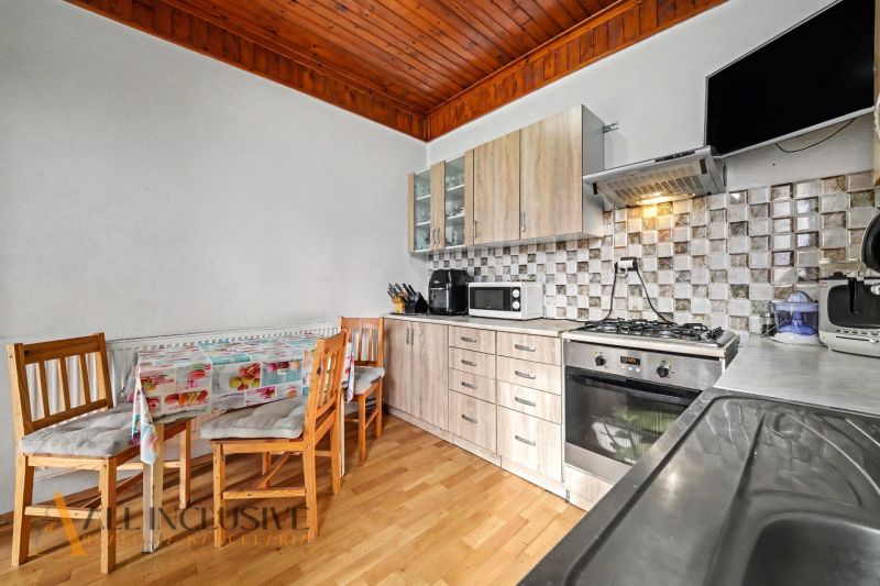 A kitchen in a family house with furnishings, a kitchen unit, and flooring with a wood decor.