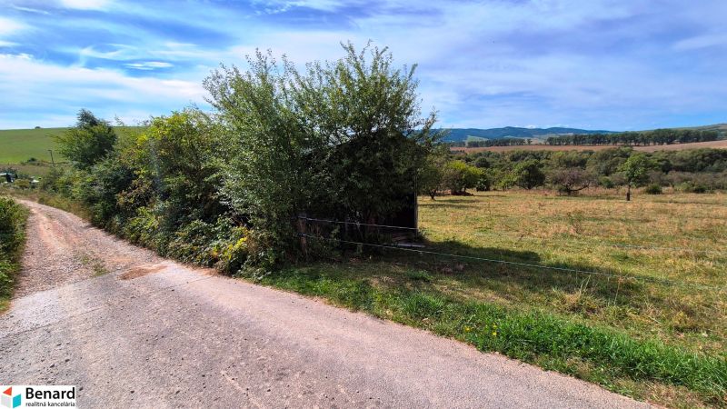 Lands - housing in Jarabina with greenery and a country road under a blue sky.