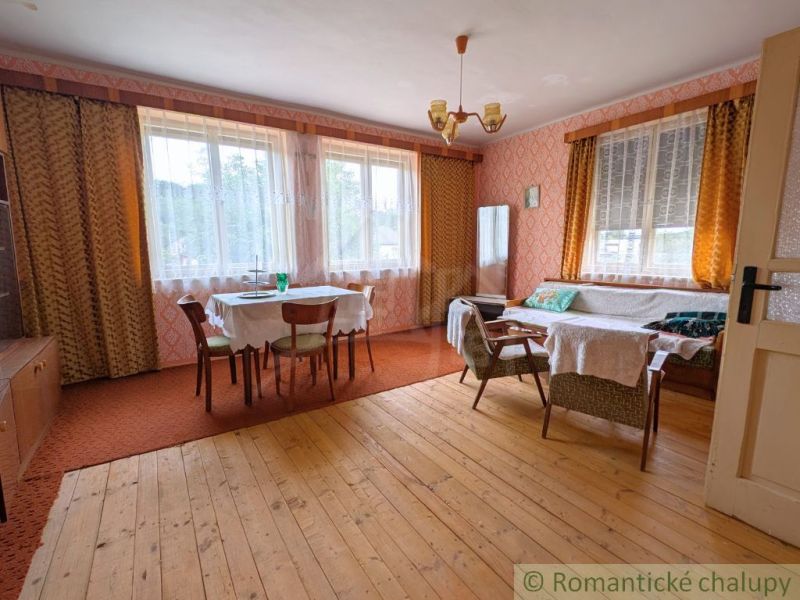 Living room with wood-patterned flooring, a dining table, and comfortable seating.