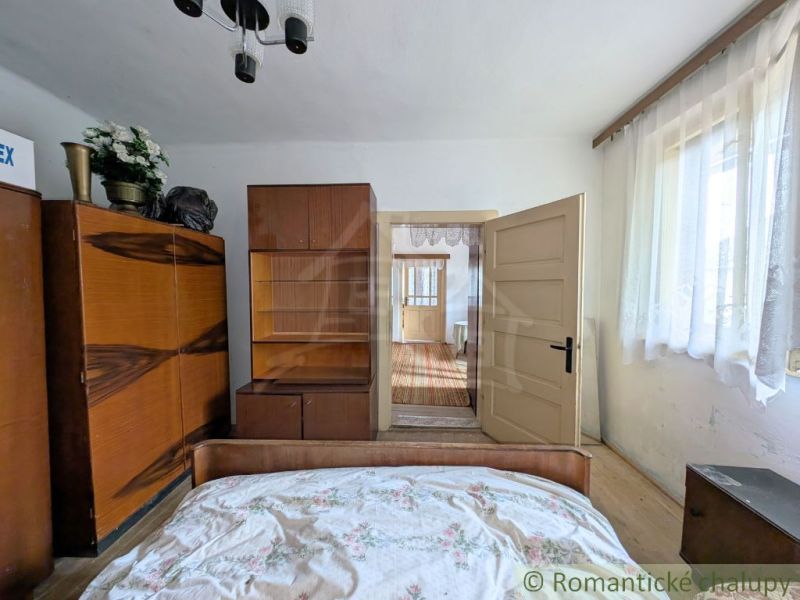 Interior of a family house with wooden cabinets and a bed, light walls, curtains.