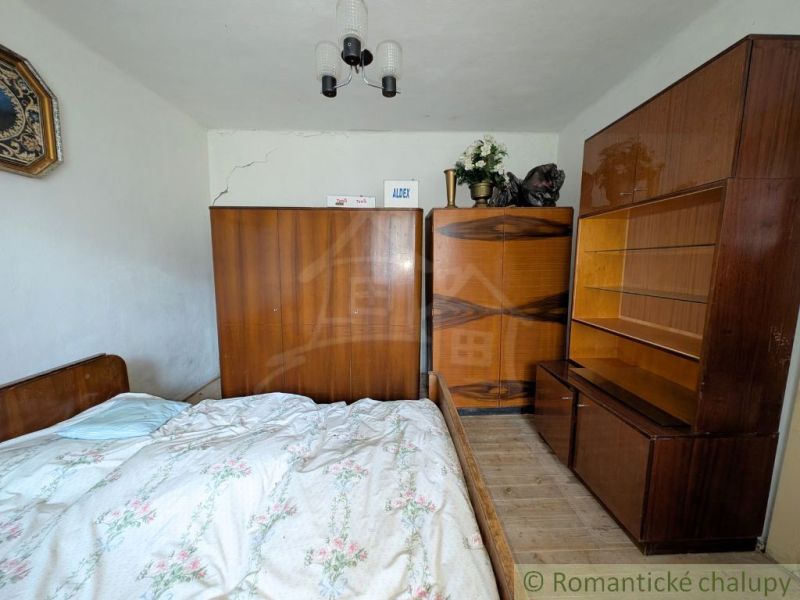 The interior of the family house includes a bed, a wardrobe, and a floor with a wooden decor.