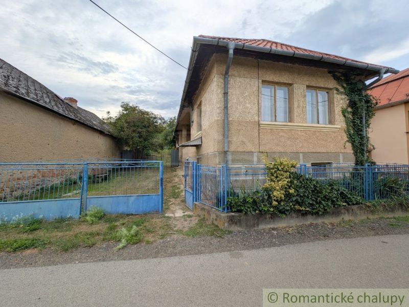 A family house in Nižné Ladičkovce with a garden, fence, and shingle roof.