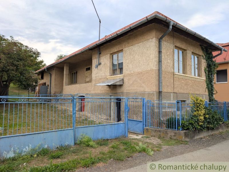 A family house in Nižné Ladičkovce with a blue fence and a garden.