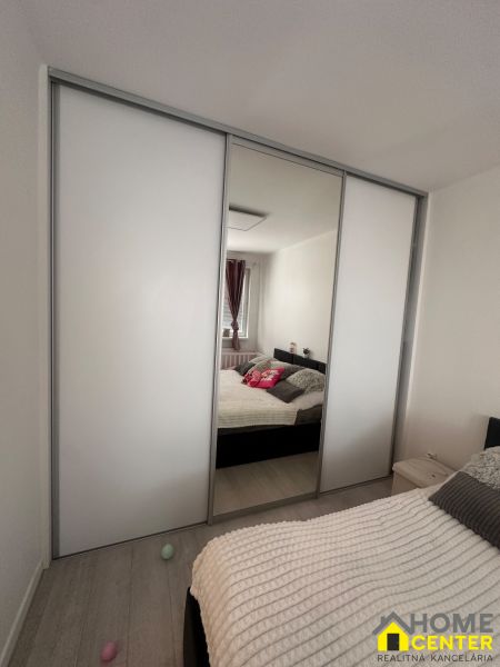 A bedroom in a 3-room apartment with a built-in wardrobe and a floor with a wooden decor.