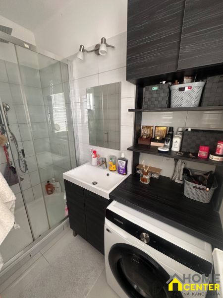 Bathroom in a 3-room apartment with a sink, shower, and washing machine.