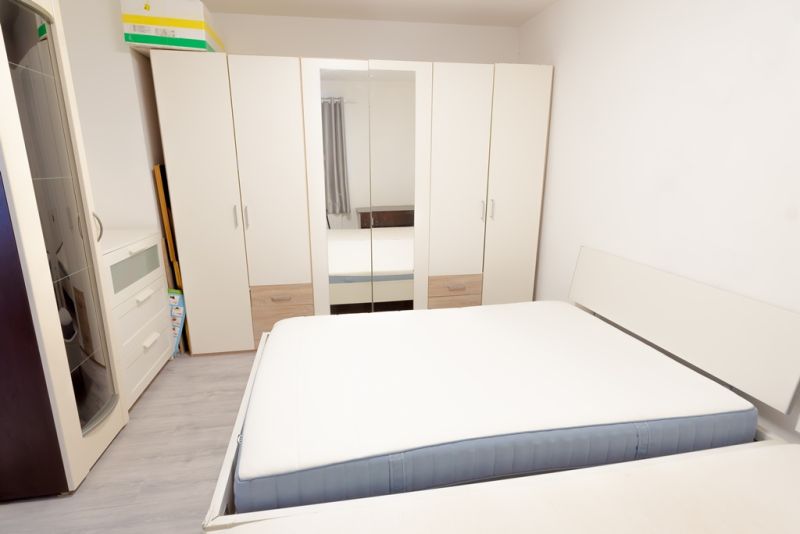 Bedroom in a family house with a large wardrobe, bed, and drawers.