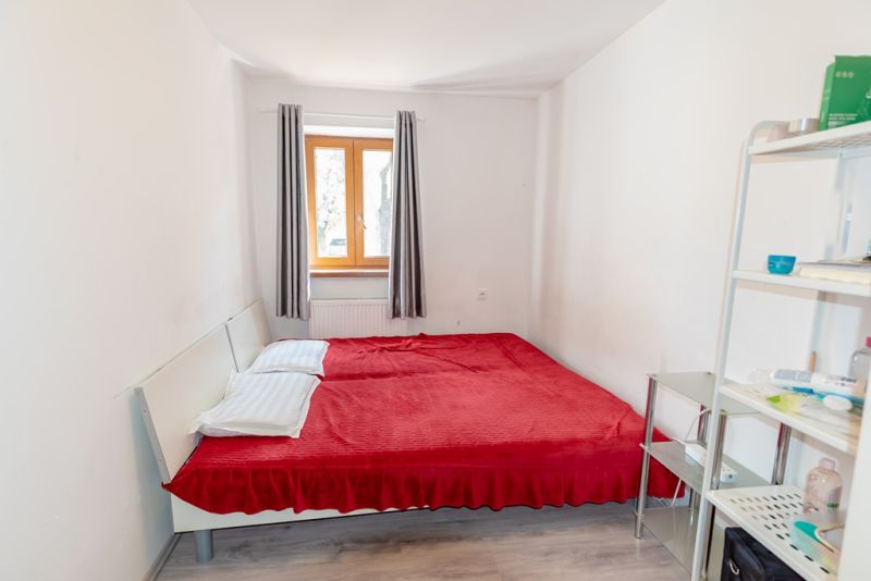 Bedroom in a family house with a window, bed, and shelf.