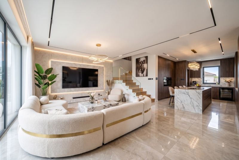 Open space with a kitchen, staircase, and comfortable living room in a family house.