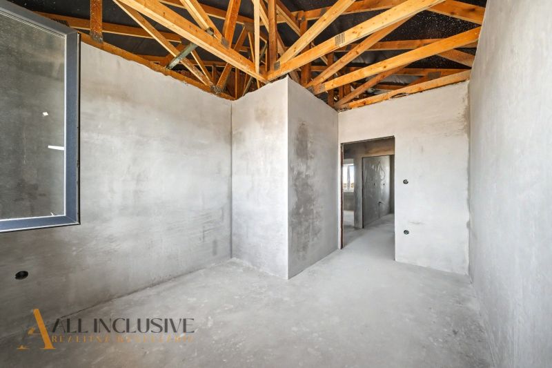 In the interior of a family house with a rough construction and a wooden ceiling beam.