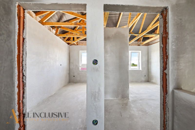 The interior of a family house with plastered walls and an uncovered ceiling.