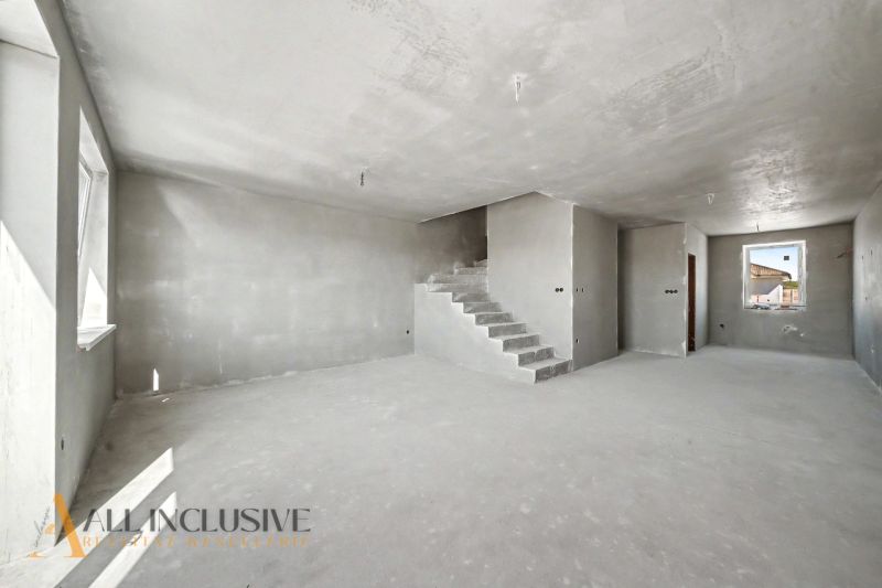 Interior of a family house with concrete stairs and plastered walls.