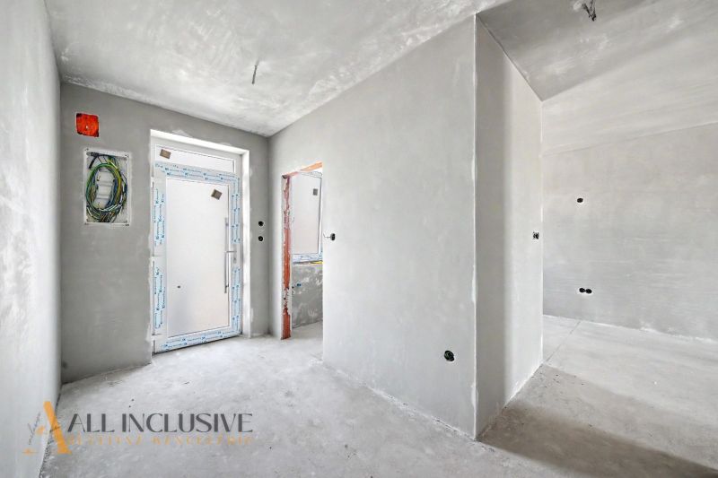 An unfurnished interior with white walls and an entrance door in a family house.