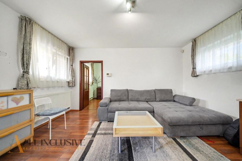 Living room with wood-patterned flooring, a sofa, and a coffee table in a family house.