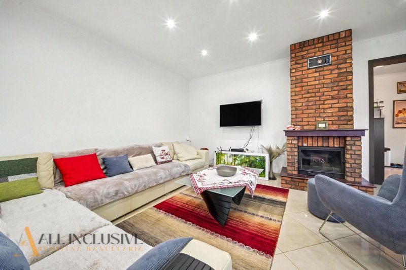 Living room in a family house with a fireplace, sofa, and colorful cushions.