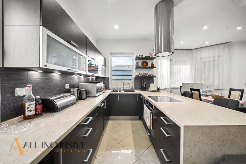 A spacious kitchen in a family house with modern equipment and a view of the garden.