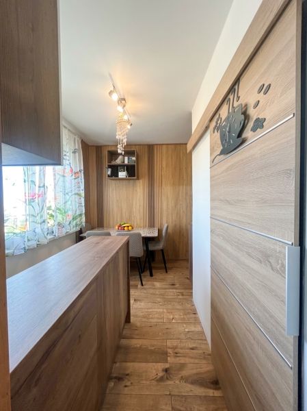 A kitchen in a 3-room apartment with a wooden decor floor and a dining table.