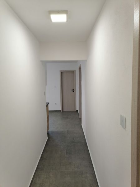 A corridor with tiles and white walls in a 2-room apartment.