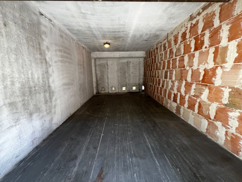 An empty garage with a wood-patterned floor and a brick wall in Dúbravka on Hanulova.
