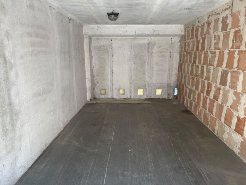 The interior of a garage with concrete walls and a floor with a wooden decor.