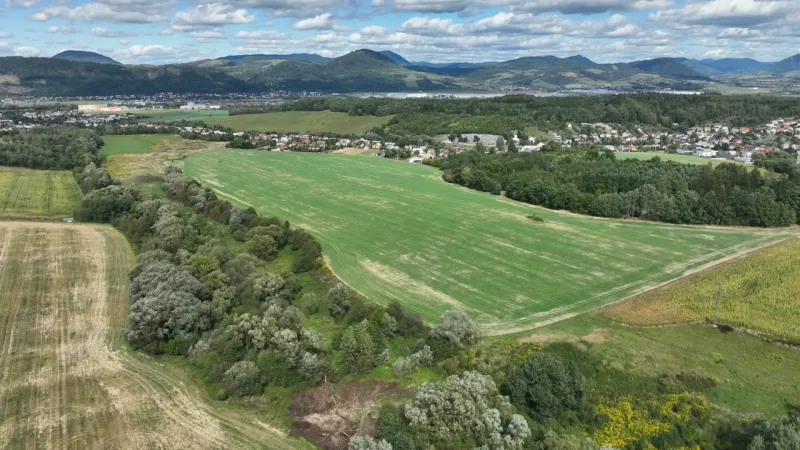 Agricultural and forest lands in Žilina with a village and hills in the background.