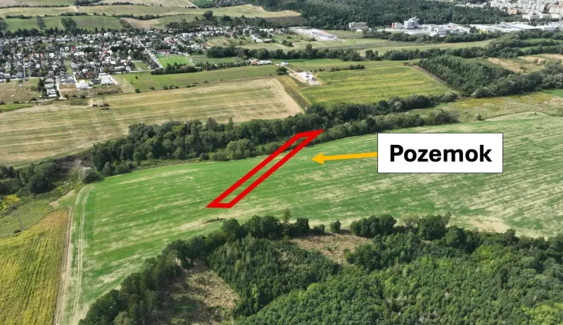 Agricultural and forest lands in the Žilina area with nearby urban developments and greenery.