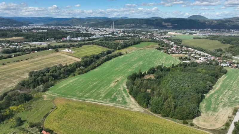 Aerial view of agricultural and forest lands near Žilina with the city in the background.