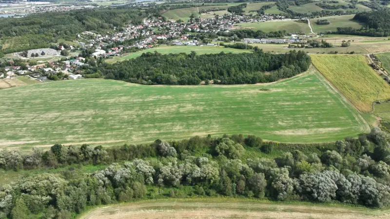 An aerial view of agricultural and forest lands around Žilina with scattered buildings.