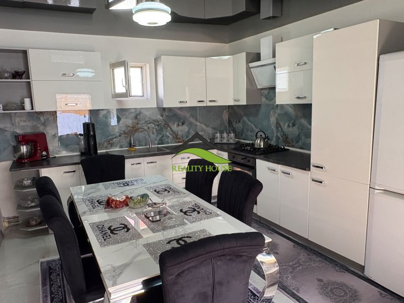 A kitchen in a family house with white cabinets, a dining table, and appliances.