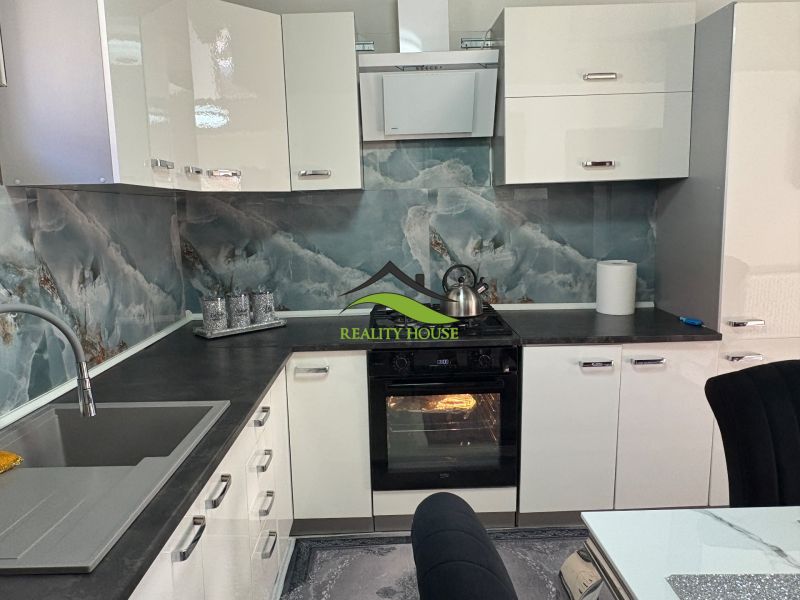 A kitchen unit in a family house with the elegance of a marble wall and modern appliances.