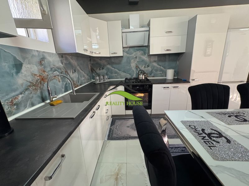A kitchen in a family house with an elegant marble wall and modern equipment.