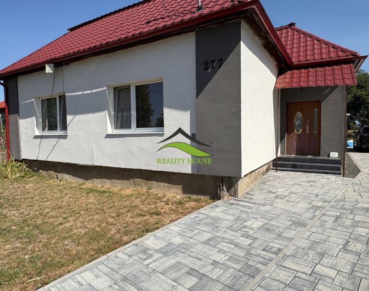 A family house on Hlavná Street in Bežovce with a red roof and a paved walkway.
