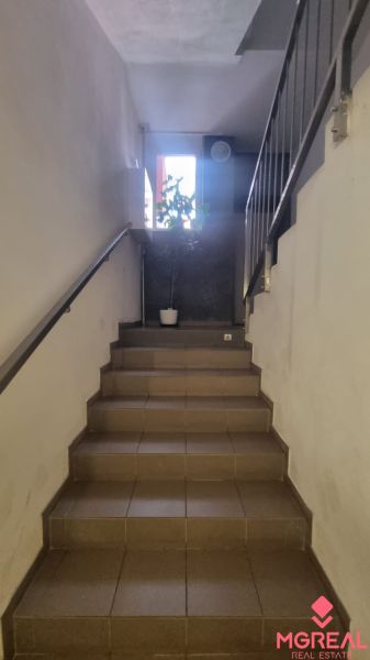 A staircase with a flower and a railing in a 2-room apartment.