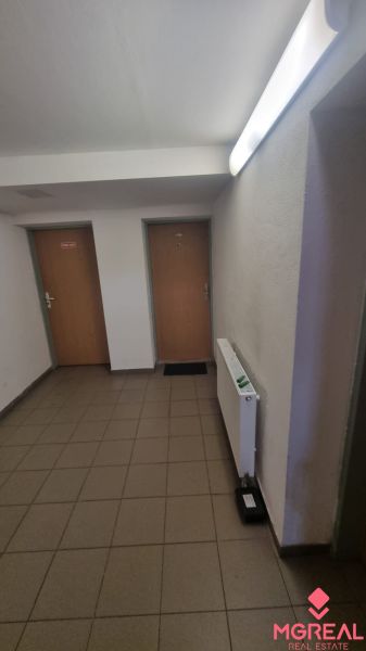 Entrance hall in a 2-room apartment with doors and a radiator, tiles on the floor.