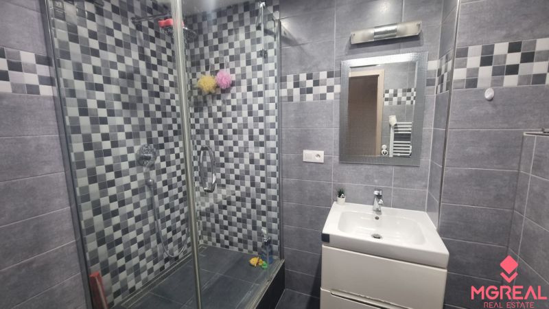 Bathroom with tiles and a shower in a 2-room apartment.